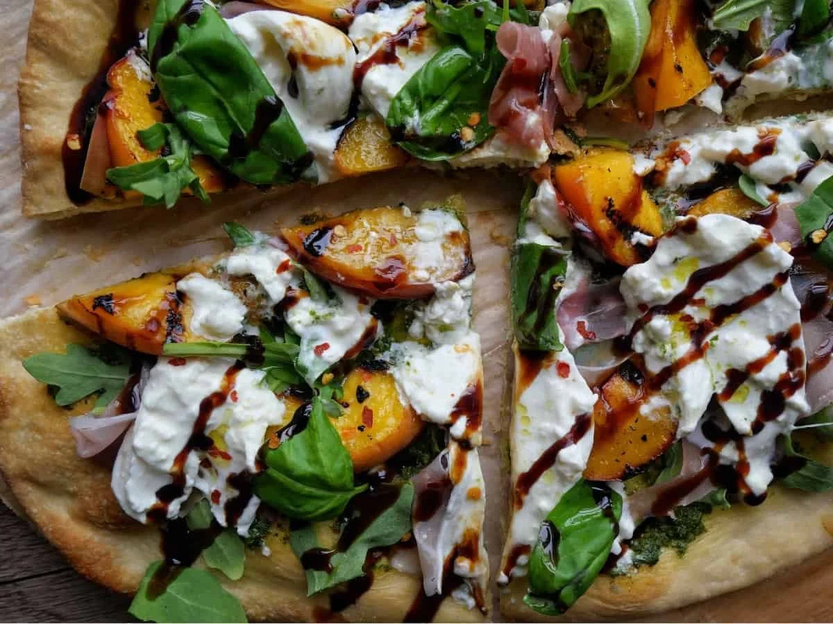 Grilled peach flatbread topped with prosciutto and fresh herbs