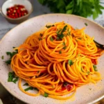 Plate of Gochujang buttered noodles garnished with fresh herbs