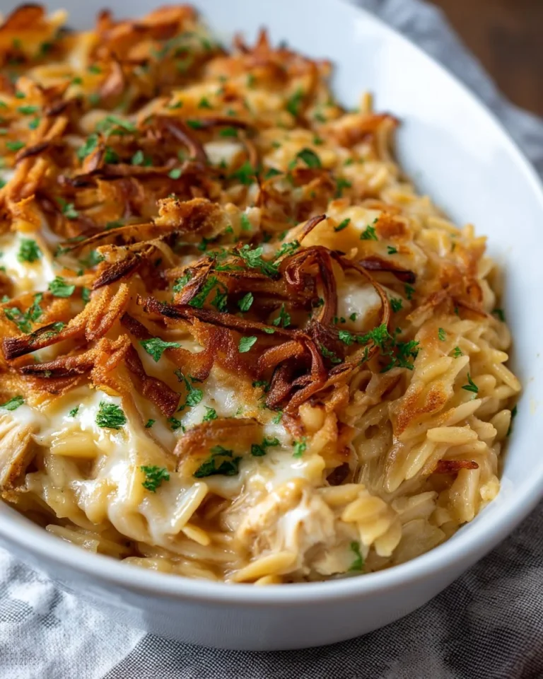 French onion chicken orzo casserole baked in a dish topped with melty cheese