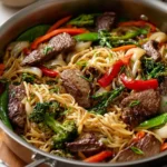 Beef and noodle stir fry with vibrant vegetables in a stir fry pan