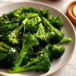 Delicious easy sauteed broccoli on a plate garnished with herbs