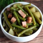 Plate of ham with potatoes and green beans served for dinner