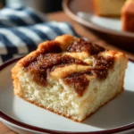 A slice of old-fashioned cinnamon flop cake topped with cinnamon sugar.
