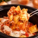 Comforting Crockpot Ravioli Lasagna with layers of ground beef, marinara, and cheese.