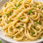 Delicious one-pot garlic pasta recipe topped with fresh herbs and cheese.