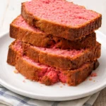 Slice of homemade Strawberry Banana Bread on a wooden table.