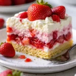 Slice of Strawberry Earthquake Cake topped with fresh strawberries and icing