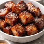 Plate of crispy keto pork belly bites garnished with herbs