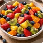 Fresh fruit salad with honey lime poppy seed dressing served in a bowl