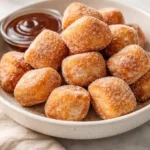Delicious healthy air fryer churro bites served on a plate, sprinkled with cinnamon sugar.