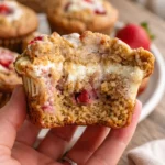 Vegan gluten-free strawberries & cream muffins on a wooden table