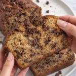 Delicious slice of chocolate chip banana bread on a wooden table