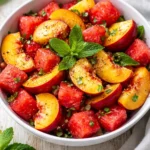 Colorful peach watermelon salad with fresh berries and mint leaves