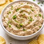 Delicious brandied caramelized onion dip in a serving bowl with chips