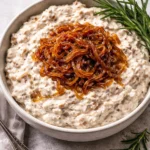 Delicious caramelized onion dip served with fresh vegetable sticks and crackers.