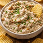 Delicious caramelized onion dip in a bowl served with crispy chips.